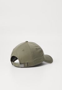 Bomull baseball cap i olivengrønn med buet skjerm, justerbar stropp bak og ventilasjonsåpninger på kronen.