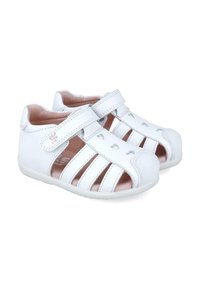 Sandalias para toddlers de cuero blanco con diseño perforado, cierre de correa y un interior acolchado. Punta redonda y suela de goma flexible.