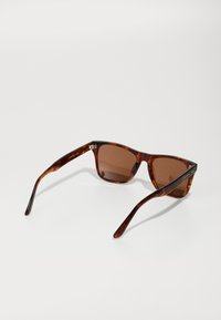 Ochelari de soare tortoise brown cu rame rectangulare, lentile maro cu gradient și temple subțiri ce prezintă accente din metal argintiu.