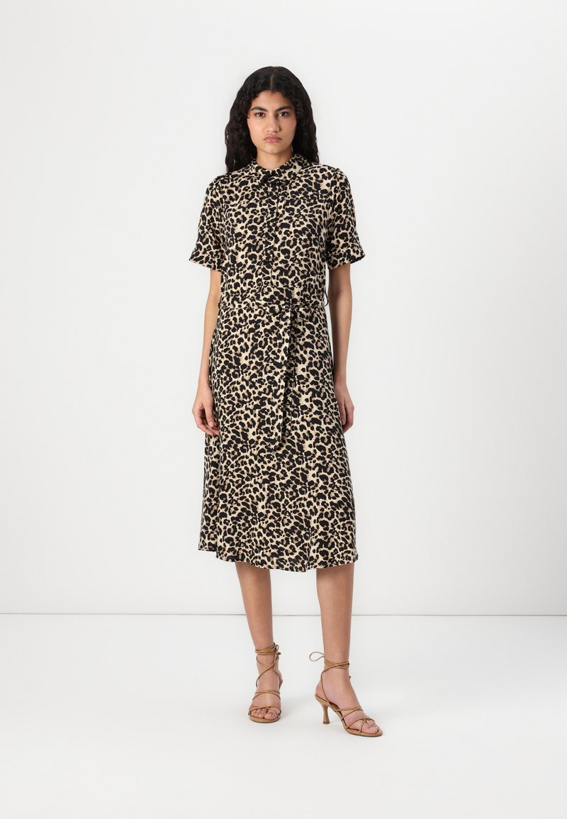 Leopardmönstrad midi-klänning med korta ärmar, knappstängning och knytmidja. Buren med strapsandaler i beige mot en enhetlig bakgrund.