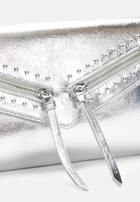 Sølvmetallisk clutch med teksturert overflate, som har to glidelåser og dekorative metallpigger langs den øverste kanten.