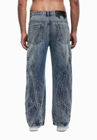 Τζιν παντελόνια σε ανοιχτό μπλε χρώμα με άνετη εφαρμογή. Διαθέτουν χαρακτηριστικό ραφές σε ζικ ζακ και δύο πίσω τσέπες. Ζωνάρι στη μέση με λεπτομέρεια λογοτύπου.