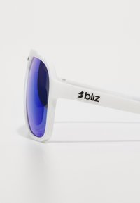 Weiße Kunststoff-Sonnenbrille mit blauen, verspiegelt wirkenden Gläsern, ausgestattet mit einem quadratischen Rahmen und dem Markenlogo "bliz" an der Seite.