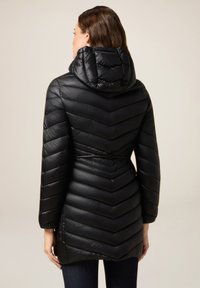 Zwarte pufferjas met een chevron-gequilt patroon, capuchon, lange mouwen en een trekkoord in de taille. Glad, glanzend textuur.