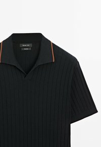 Polo shirt a maniche corte in cotone nero con una texture a coste e dettagli marroni sul colletto. Presenta un design del colletto classico.