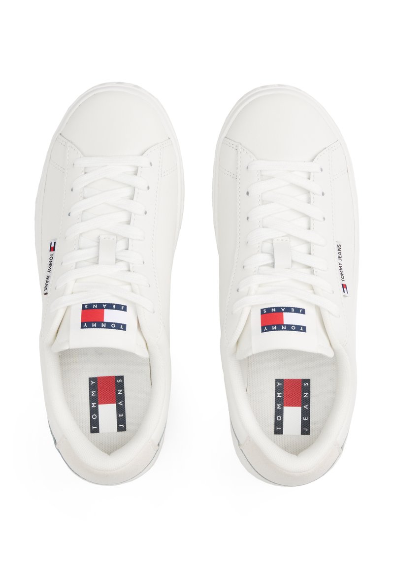 Sneakers bianchi con tomaia in pelle liscia, punta rotonda, lacci piatti e linguetta imbottita. Presentano etichette con marchio in rosso, bianco e blu.