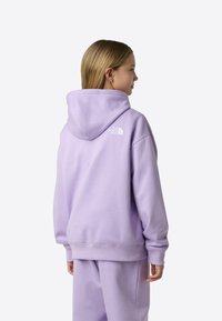 Fialová mikina s kapucňou a pružnými manžetami, na zadnej strane s malým bielym logom, vyrobená z mäkkého teplákového materiálu.