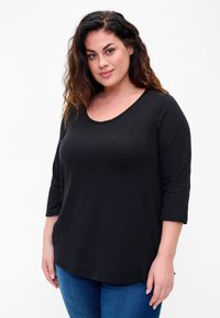 Black, loose-fitting T-shirt with a scoop neckline and three-quarter sleeves. Smooth cotton fabric, designed for comfort and ease of movement.