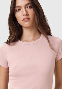 Lichtroze, aansluitend T-shirt met korte mouwen en een ronde hals, gemaakt van soepel, rekbaar katoenmix stof.
