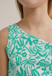 Top sin mangas de estampado tropical verde con textura acanalada, que presenta un diseño de un solo hombro y patrones vibrantes de hojas y flores.