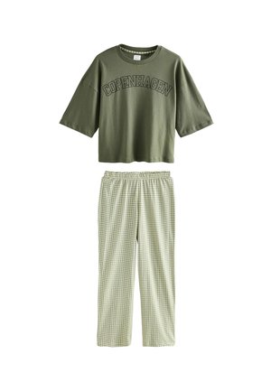 Camiseta corta color verde oliva con la inscripción "COPENHAGUE", combinada con pantalones de pijama a cuadros verde claro con cintura elástica.