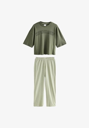 Camiseta corta color verde oliva con la inscripción "COPENHAGUE", combinada con pantalones de pijama a cuadros verde claro con cintura elástica.