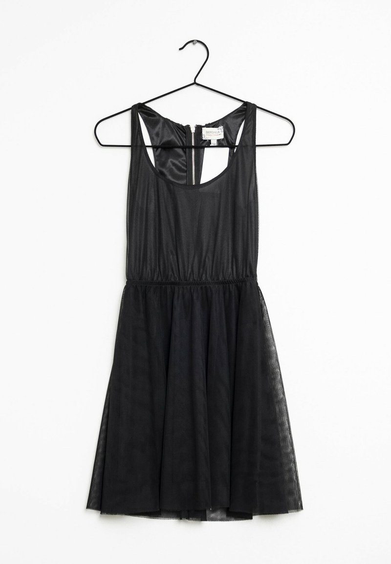 Svart klänning med figursydd överdel, ärmlös design och en utsvängd kjol i genomskinligt tyg. Har en dragkedja bak.