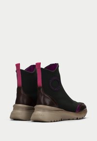 Botines negros y marrones con acentos rosas, parte superior de cuero suave y textil texturizado, suela beige acolchada, detalle de logo circular.