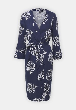 Robe portefeuille bleu marine avec motif floral blanc, manches longues et ceinture à nouer à la taille. Fabriquée en tissu léger.