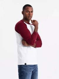 Langärmliges Raglan-Shirt mit kastanienbraunen Ärmel und weißem Körper, mit einem runden Halsausschnitt und einem kleinen schwarzen Etikett am Saum.