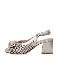 Silver slingback sandal with open toe, geometric cutout design, and a chunky heel. Features a rounded accent on the front.