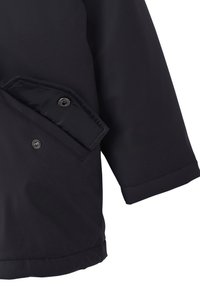 Schwarzer Jackenärmel mit einer teilweise geöffneten Druckknopfklapptasche, die Nähdetails und Stoffstruktur zeigt.