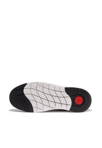 Schuhsohle mit weißem Grund und schwarzen Gummibereichen. Verfügt über strukturierte Muster für besseren Halt und einem roten runden Akzent im Fersenbereich.