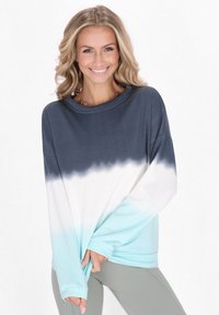 Maglietta a maniche lunghe con gradiente, presenta colori blu scuro, bianco e verde acqua. Tessuto morbido, vestibilità comoda, scollatura rotonda. Dettagli di cucitura minimali nelle cuciture.