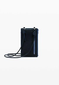 Marinblå läder crossbody-väska med sidodragkedja, justerbara axelremmar och knutdetaljer. Slät textur med en strukturerad rektangulär form.