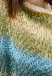 Maglione a maglia con design gradiente in morbidi toni di blu, giallo e crema. Tessuto strutturato con scollatura a girocollo e dettagli a coste.