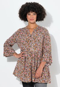 Top peplum floreale con scollatura a V, maniche a 3/4 svasate e uno sfondo scuro con motivi multicolori. Tessuto leggero con una vestibilità comoda.