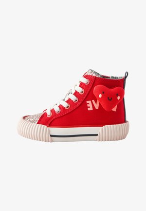 Roter High-Top-Sneaker mit weißen Schnürsenkeln, glitzernder Zehenkappe, einem angenähten lächelnden Plüschherz und teilweise sichtbarem weißen Text an der Seite.