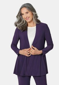 Lila Langarm-Cardigan mit fließendem Design, kombiniert mit einem weißen Oberteil mit dezenten Verzierungen. Glatter Stoff und bequeme Passform.