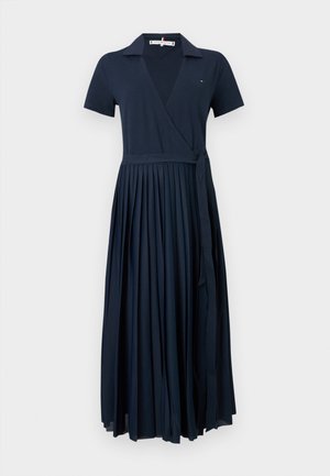 Tumedas sinine lühikeste varrukatega pakkedress, millel on krae, volditud seelikuosa ja külgmine lips.