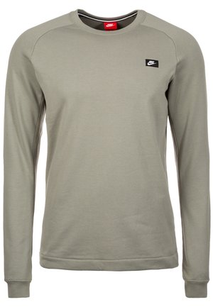 Sweat-shirt Nike vert olive clair à manches longues avec col rond et petite écusson noir du logo Nike sur le côté gauche de la poitrine.