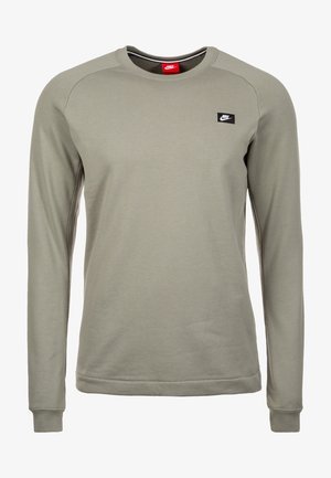 Sweat-shirt Nike vert olive clair à manches longues avec col rond et petite écusson noir du logo Nike sur le côté gauche de la poitrine.