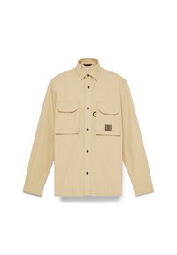Beige langemouwen shirt gemaakt van lichtgewicht stof, met twee borstzakken met knoopsluitingen en een logo flap op de linkerzak.