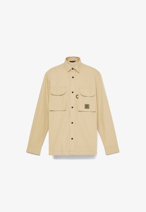 Beige langemouwen shirt gemaakt van lichtgewicht stof, met twee borstzakken met knoopsluitingen en een logo flap op de linkerzak.
