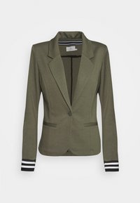 Veste blazer vert olive avec un bouton unique et deux poches avant. Présente des accents rayés noirs et blancs sur les poignets. Texture de tissu lisse.