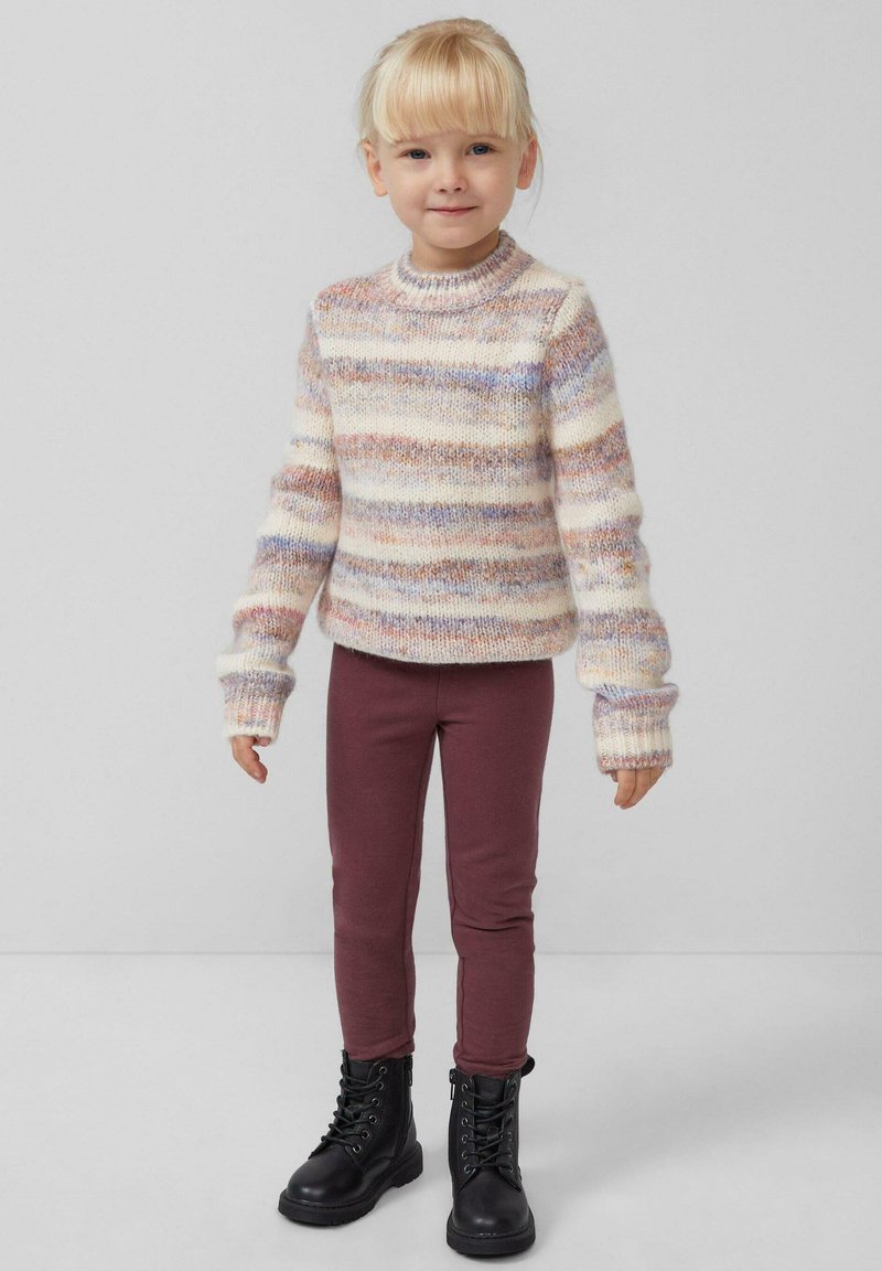 Multicolore gebreide trui met tinten van crème, roze en blauw, gecombineerd met bordeaux leggings en zwarte veterschoenen. Comfortabele pasvorm en lange mouwen.