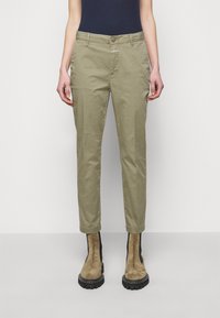 Olivgröna byxor med rak passform, framfickor och knappstängning. Kompletteras av bruna mocka ankelskor med svarta detaljer.