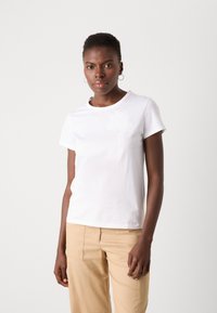 White cotton t-shirt with a rounded neckline and short sleeves. Features a subtle floral embroidery design on the front.