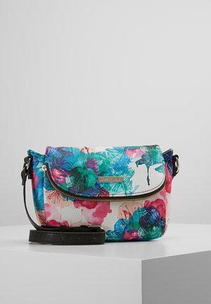 Lille crossbodytaske med flerfarvet blomstermønster, gyldent lynlås og sort justerbar rem, der ligger på en hvid overflade.