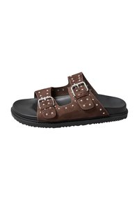 Sandali in suede marrone con due cinture regolabili, fibbie argento e borchie su una suola in gomma nera, caratterizzati da un design open-toe.