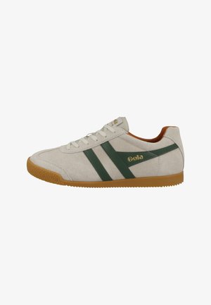 Sneakers in suede con strisce verdi e logo dorato. Presentano una suola in gomma testurizzata e una cavigliera imbottita, con una combinazione di colori bianco e beige.