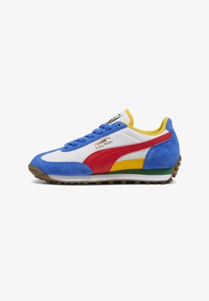 Sneaker Puma Easy Rider con tomaia in suede blu, pannelli sintetici bianchi, accenti rossi e gialli, suola intermedia verde e suola esterna in gomma marrone.