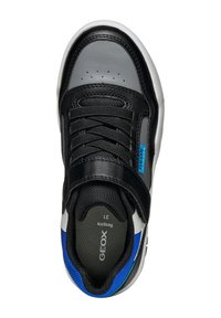 Zapatillas de deporte de piel negra y rejilla con acentos grises, detalles azules, una suela texturizada y una correa de Velcro sobre los cordones para un ajuste seguro.