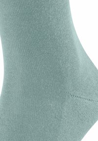 Helle teal Baumwollsocke mit geripptem Textur und glatter Oberfläche, verstärkten Nähten und einem geschwungenen oberen Rand.