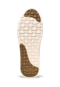 Sula på skon har en ljus creamfärg med ett strukturerat bikake-mönster och en kontrasterande brun sektion nära hälen. "Cole Haan Flowerflex" präglat.