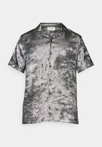Camicia a maniche corte con bottoni in tessuto metallico argento con un motivo testurizzato; colletto classico; cinque bottoni neri sul davanti.