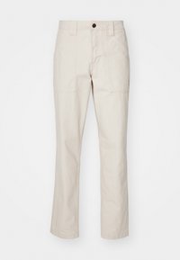 Beige bomuldsbukser med lige ben-design, der har to frontlommer, en enkelt knaplukning og synlige stikninger.