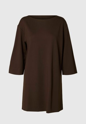 Robe ample de couleur marron foncé, avec des manches trois-quarts et un col rond, sur un fond clair uni.