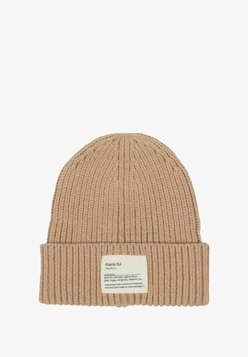 Beige ribbed knit beanie with folded cuff featuring a fabric label defining "thank-ful" and listing synonyms and its meaning.