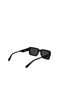 Ochelari de soare negri, rectangulari, cu lentile întunecate, având ramă groasă și brațe subțiri. Brațul stâng are un logo de marcă gravat în alb.